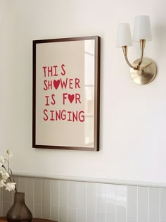 a bathroom with a sink and mirror next to a wall mounted art piece on the wall