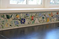 a window sill with flowers painted on the side and windowsills behind it