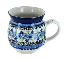 a blue and white coffee cup with floral designs on the bottom, sitting in front of a white background