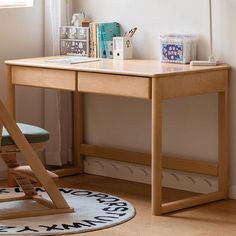 a wooden desk with a chair next to it and a window in the back ground