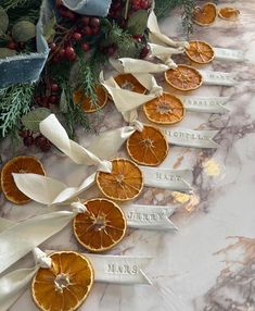 orange slices are arranged in the shape of ribbons on a marble counter top with holly and berries