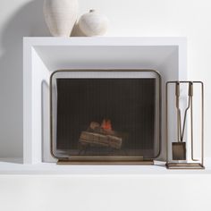 a fire place with two white vases sitting on top of it