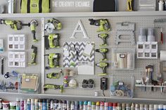 there are many different paint cans on the wall in this garage storage area that is organized with pegs and shelves