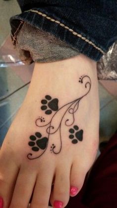 a foot with a tattoo on it that has hearts and paw prints in the middle