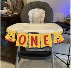 a winnie the pooh baby high chair with one banner hanging from it's side