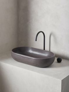 a bathroom sink sitting on top of a counter next to a wall mounted faucet