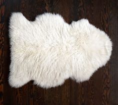 a white sheepskin rug laying on top of a wooden floor