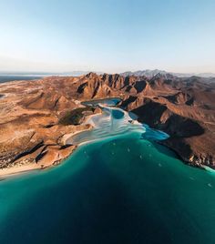 an aerial view of the water and land in the desert, looking down at mountains