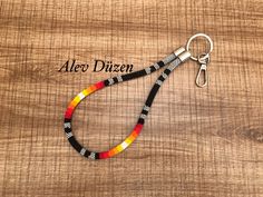 a multicolored lanyard on a wooden surface with the name alex dizen