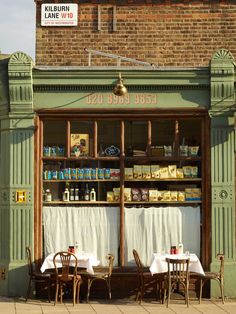 the outside of a restaurant with tables and chairs