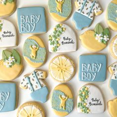 baby shower cookies decorated with blue and yellow icing are arranged on a white surface