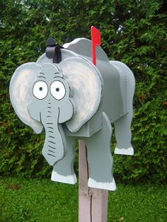 an elephant mailbox with a red stick sticking out of it's trunk