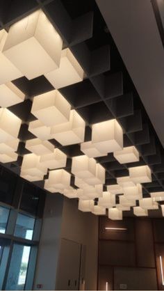 the lights are hanging from the ceiling in the building's office space, which is decorated with square and rectangle shapes