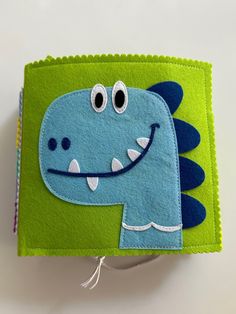 a close up of a small wallet with a cartoon dinosaur on it's side