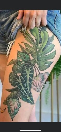 a woman's thigh with flowers and leaves on it