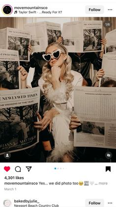 a woman in sunglasses holding up newspapers while another person looks at her cell phone and takes a selfie