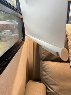 the interior of an rv with couches and windows looking out onto a yard area