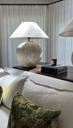 a lamp sitting on top of a table next to pillows