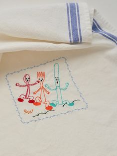 an embroidered towel with two cartoon characters on it and a blue stripe around the edge