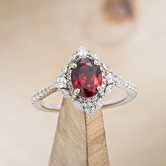 a close up of a ring with a red stone