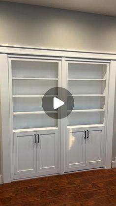 an empty room with white bookcases and wood floors