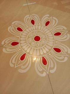 a white and red design on the floor in a room with light coming through it