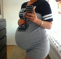 a pregnant woman is taking a selfie with her cell phone