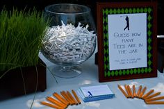 there are many pieces of paper in the bowl and on the table is a sign that says guess how many tees are in the jar