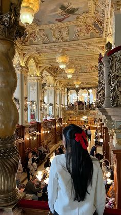 a woman standing in the middle of a room with many chandeliers and lights