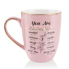 a pink coffee mug with the words you are written on it and flowers in gold trimmings