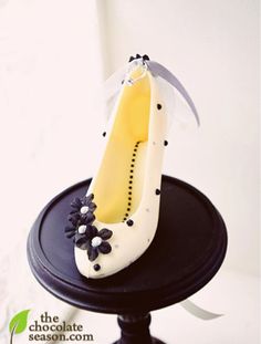 there is a cake shaped like a shoe on top of a stand with a knife sticking out of it