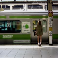 a woman is waiting for the train to arrive