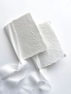 two white napkins with the word vows printed on them are laying next to each other