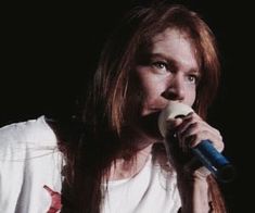 a woman with long hair holding a microphone