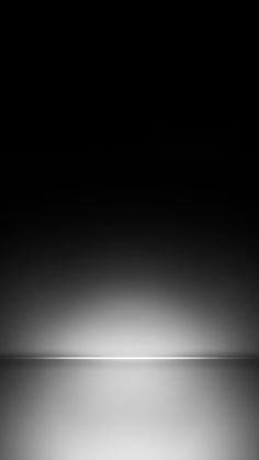 a black and white photo of a light reflecting on the floor in the dark room