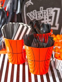 halloween themed party with orange and black plastic buckets filled with forks, spoons and utensils