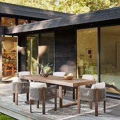 an outdoor dining table and chairs in front of a large glass doored patio area