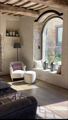 a living room filled with furniture next to a large window covered in windowsills