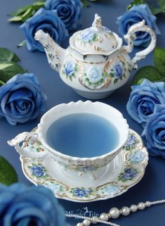 blue roses and teapots are on the table