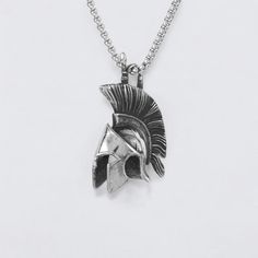 a silver necklace with a spartan helmet on it