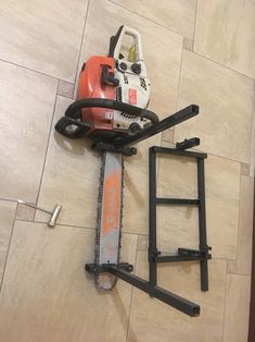 a chainsaw is laying on the floor next to a ladder