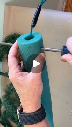 a person is using a drill to fix a hole in a toilet paper roll with a screwdriver