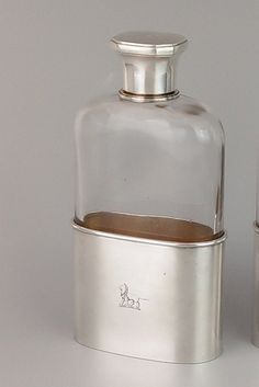 an empty glass bottle next to a silver container