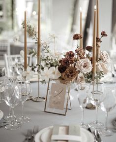 the table is set with candles, flowers and place cards for guests to write their names