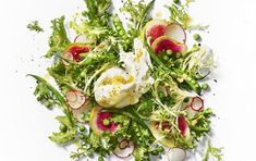 a salad with radishes, onions and eggs in it on a white surface