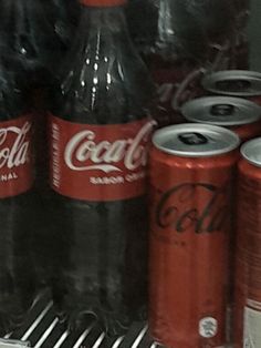 coca - cola cans are stacked on top of each other