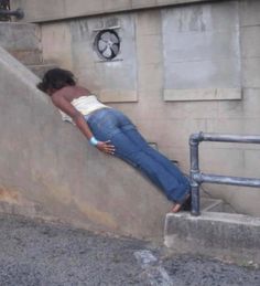 a woman leaning up against the side of a wall