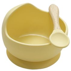 a yellow bowl with a wooden spoon in it and a white lid on the side