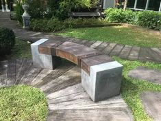 a concrete bench sitting on top of a wooden walkway