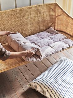 a person is laying on a couch with pillows and a pillow in front of them